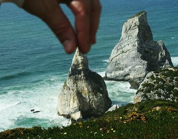 Low section of man on rock at beach