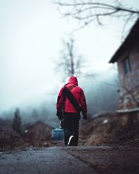 Rear view of person walking on snow covered trees