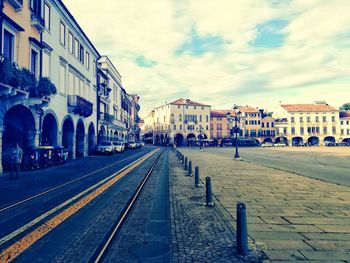 Street amidst buildings in town against sky