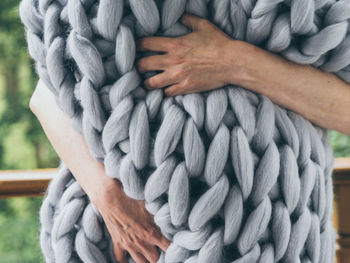 Midsection of woman embracing rug