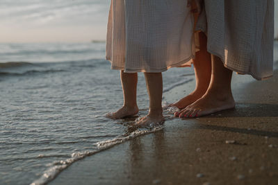 Low section of woman standing on beach