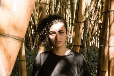 Portrait of young woman against tree