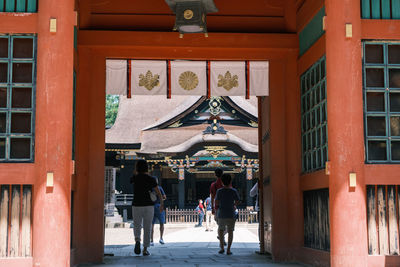 Rear view of people walking on building