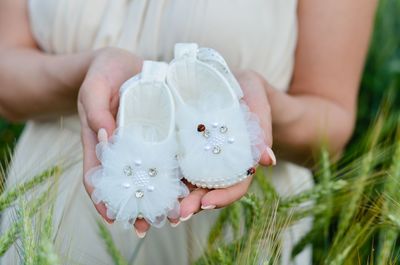 Midsection of woman holding white flower