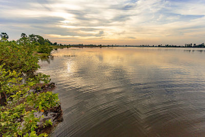 Scenic view of river against sky at sunset