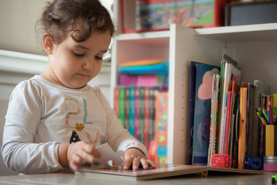 Close-up of girl holding jigsaw puzzle on table at home