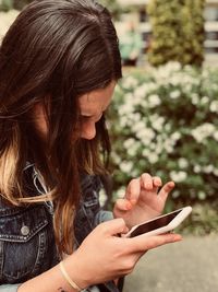 Woman using phone while standing outdoors