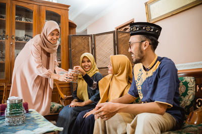 Woman giving snacks to guests at home