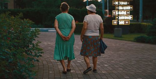 Rear view of friends walking on street