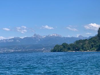 Scenic view of sea and mountains against sky