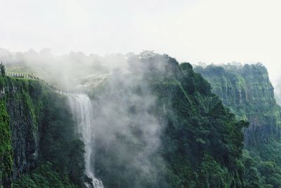 Scenic view of waterfall against sky