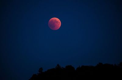 Low angle view of moon against clear blue sky