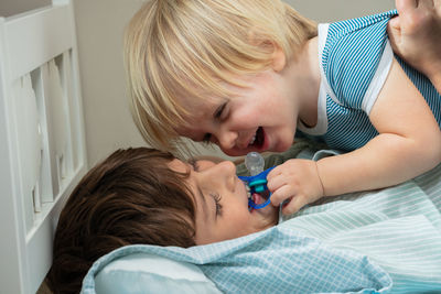 Side view of girl playing with daughter at home