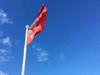 Low angle view of flag against blue sky