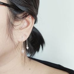 Close-up of woman wearing earrings against white background