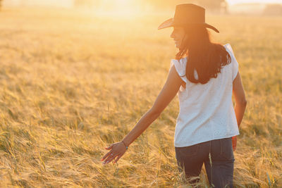 Rear view of woman walking on field