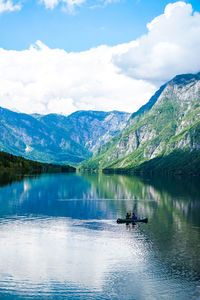 Scenic view of lake by mountains against sky