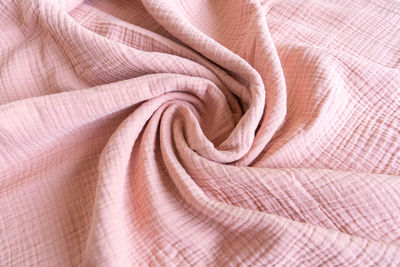 Soft muslin baby blanket. cotton and textiles. natural organic fabrics texture. light pink color. 