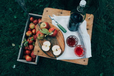 High angle view of apples with drink on wooden table in farm