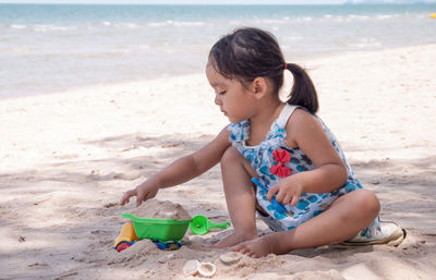 Girl playing with toys at beach