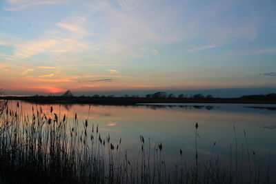 Scenic view of calm lake at sunset