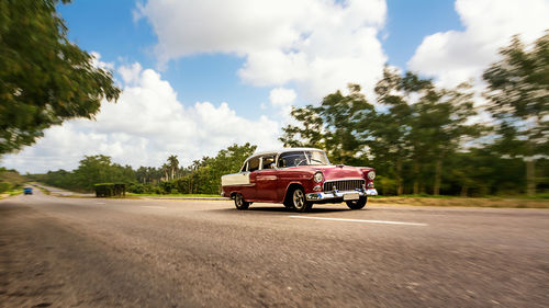 Car on road against cloudy sky