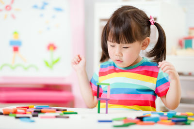 Young girl playing counting stick at home
