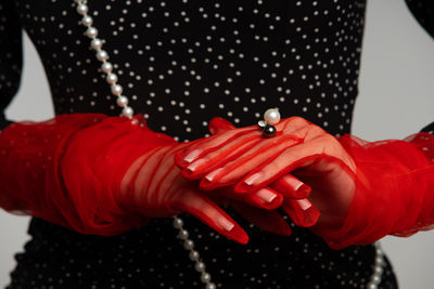 Cropped hand of woman holding hands jelwery red color details