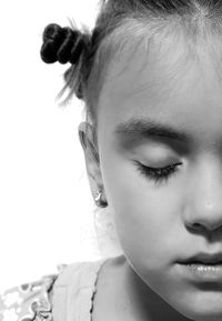 Close-up of girl with closed eyes against white background