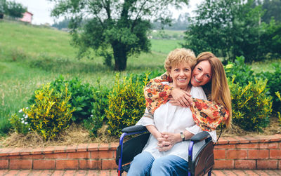 Portrait of cheerful mother and daughter in public park