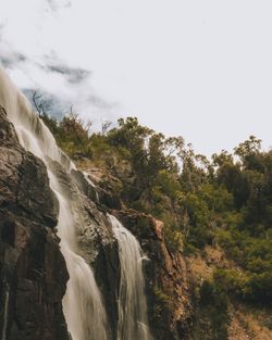 Scenic view of waterfall against sky