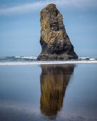 Rock formation on sea against sky