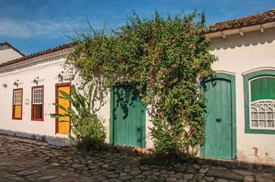 Overview of cobblestone street with old houses under blue sunny sky in paraty, brazil