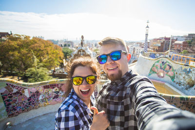 Portrait of smiling young couple against clear sky