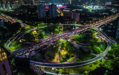 High angle view of illuminated street amidst buildings at night