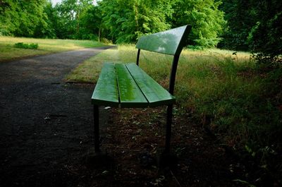 Empty bench on field in forest