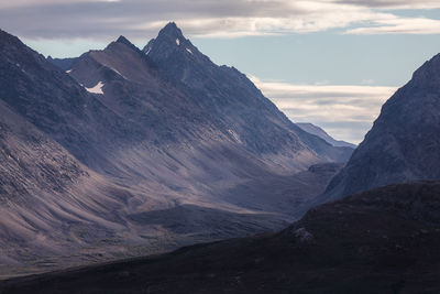 Scenic view of mountains against cloudy sky