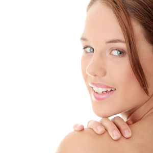 Close-up portrait of smiling young woman over white background