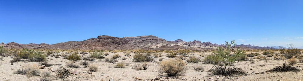 Scenic view of desert against clear blue sky