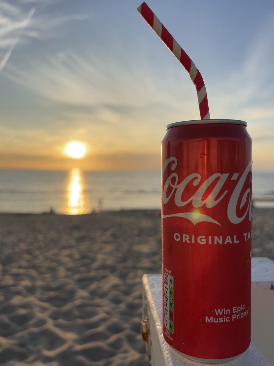 soft drink, beach, sky, drink, land, sea, water, sunset, red, nature, communication, sand, text, alcoholic beverage, cloud, western script, no people, outdoors, food and drink, vacation, focus on foreground, beauty in nature, trip, travel destinations, holiday, horizon, horizon over water, scenics - nature, sign, summer, travel, refreshment, sunlight, tranquility