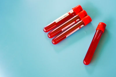 High angle view of red pen on table against blue background