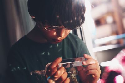 Rear view of boy using cristal with light