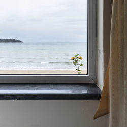 Scenic view of sea against sky seen through glass window