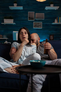 Scared couple watching movie at home