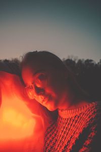 Young woman against clear sky during sunset