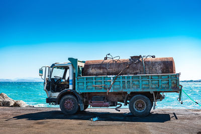 Bicycles parked on land against clear blue sky