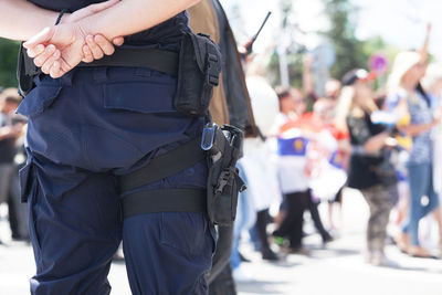 Midsection of police force against crowd during protest