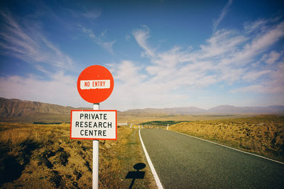 Road sign against sky