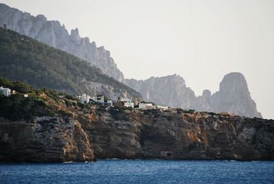 Scenic view of sea and mountains against clear sky