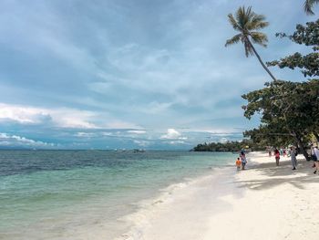 People on beach against sky